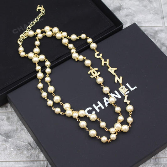 FAYZA pearl cascade long necklace with crystal lettering on a black gift box